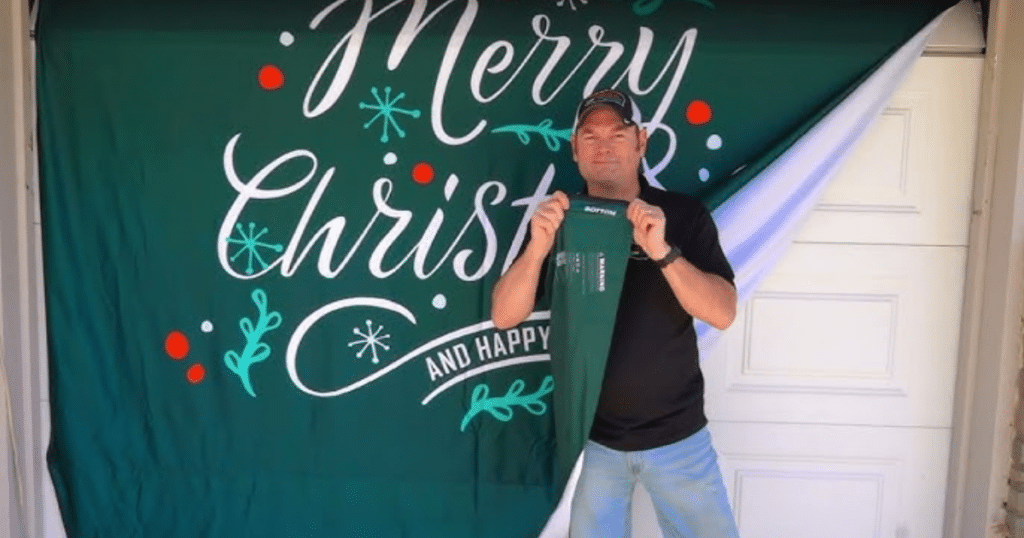 a man holding a Christmas garage door cover